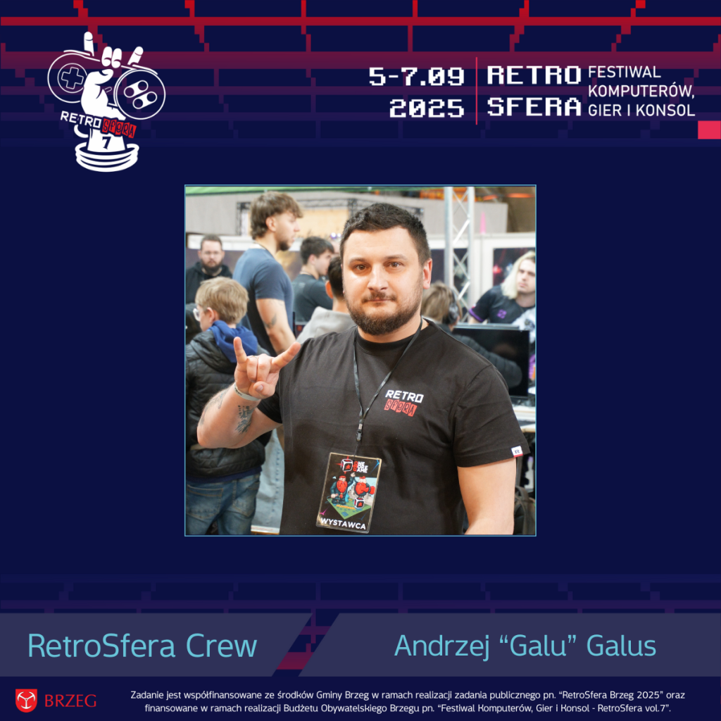 Andrzej „Galu” Galus pozuje z uśmiechem i gestem „rock on” na tle tłumu uczestników RetroSfery. Ubrany w czarną koszulkę RetroSfera i identyfikator „Wystawca”, stoi wśród stanowisk gamingowych podczas festiwalu RetroSfera vol.7. W tle widać graczy i sprzęt retro.